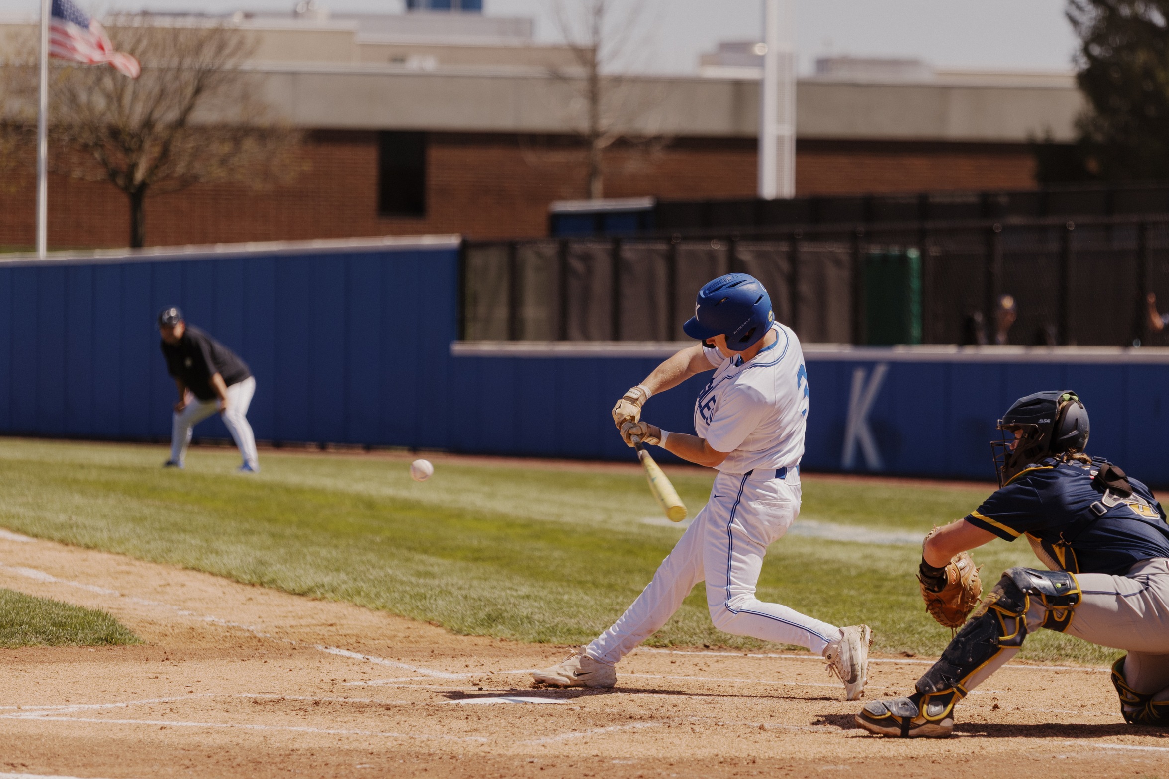 Kirkwood Eagle baeball player swinging at a pitch about to cross home plate. 